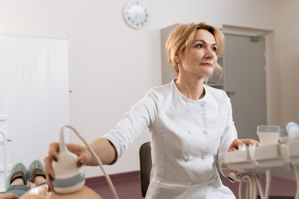 Médica ginecologista realizando ultrassom pélvico em consultório para investigar endometriose