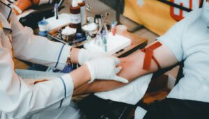 Profissional de saúde coletando sangue do braço de uma paciente para exames hormonais