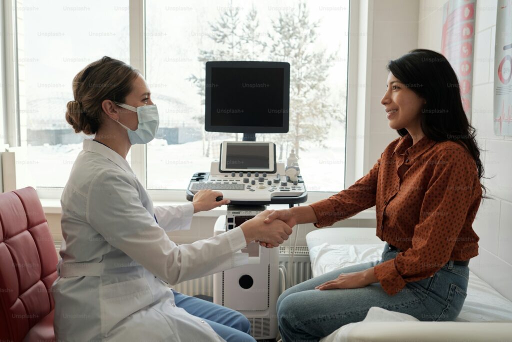 Médica e paciente conversando no consultório diante do aparelho de ultrassom