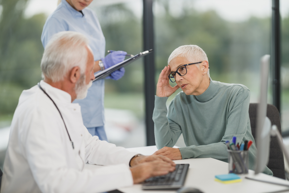 Mulher na menopausa conversando, preocupada, com o médico durante a consulta